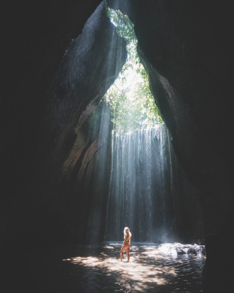 woman in cave with waterfall